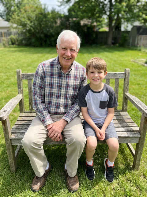 A grandfather and his grandson on a garden bench